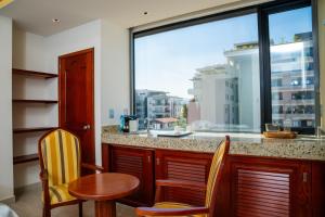 a kitchen with a table and chairs and a large window at Vallarta Live Hotel in Puerto Vallarta