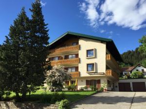 ein großes Haus mit einem Baum und einer Auffahrt in der Unterkunft Pesentheinerhof in Millstatt