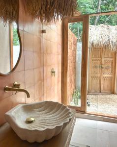 a bathroom with a stone sink and a window at Las chozas II in Tamarindo