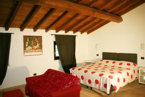 1 dormitorio con 1 cama y 1 silla roja en Agriturismo Nicobresaola, en Sommacampagna