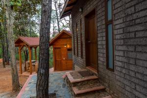 eine Blockhütte mit Veranda und Holztür in der Unterkunft Cabaña Libélula para parejas in Mascota