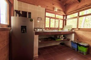 eine Küche mit Kühlschrank und Spüle in der Unterkunft Cabaña Libélula para parejas in Mascota
