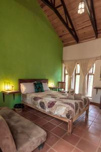 ein Schlafzimmer mit einem Bett und einer grünen Wand in der Unterkunft Cabaña Libélula para parejas in Mascota
