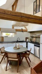 a kitchen with a table and chairs in a kitchen at A la Petite Grange in Obenheim
