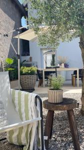 a patio with a bench and a table with plants at A la Petite Grange in Obenheim