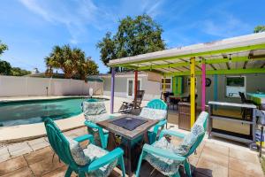 a patio with a table and chairs next to a pool at Pinellas Park Cottage in St. Petersburg