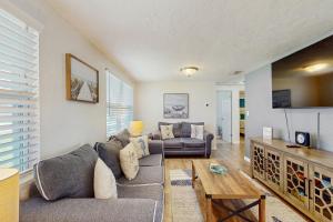 a living room with a couch and a table at Pinellas Park Cottage in St. Petersburg