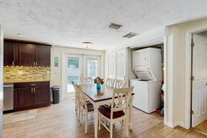 a kitchen with a table and chairs and a refrigerator at Pinellas Park Cottage in St. Petersburg