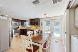 a dining room with a table and chairs and a kitchen at Pinellas Park Cottage in St. Petersburg +17 photos