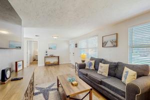 a living room with a couch and a table at Pinellas Park Cottage in St. Petersburg