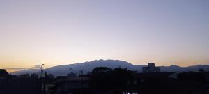 a sunset over a city with mountains in the background at Abellas Vale Ap - Aconchego in Resende