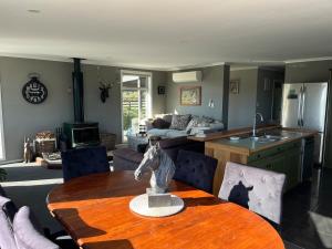a living room with a wooden table and a kitchen at Glacier Lake House in Tatare