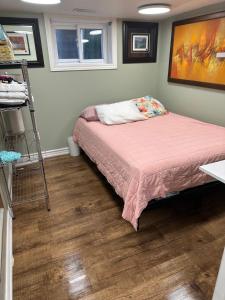 een slaapkamer met een bed en een schilderij aan de muur bij Toronto Upper Beaches Apartment in Toronto