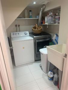 een kleine keuken met een fornuis en een wasmachine bij Toronto Upper Beaches Apartment in Toronto +6 foto's