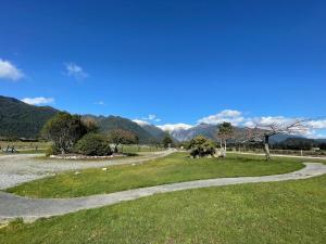 a winding path in a park with mountains in the background at Glacier Cottage in Tatare