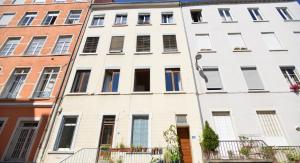 a white building with many windows on a street at Appart' Sainte Clotilde in Lyon