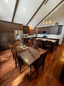 a large kitchen with wooden floors and wooden tables and chairs at Grizzly Den in Valemount