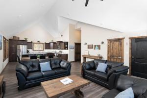 a living room with black leather furniture and a kitchen at Summit View in Valemount