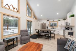 a living room with a table and a kitchen at The Alpine Cabin in Valemount