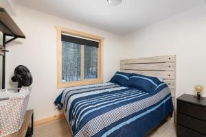 a bedroom with a bed and a window at The Alpine Cabin in Valemount
