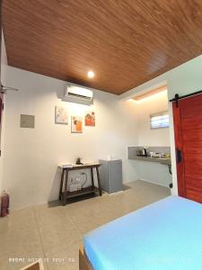 a bedroom with a bed and a table in a room at Casa Marilag Guest House in Siquijor