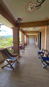 a porch with rocking chairs on a building at Hotel-Jardín Bella Oaxaca in Oaxaca City