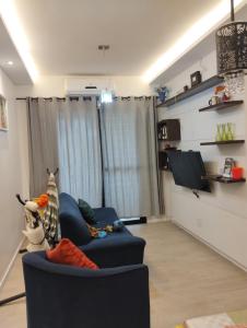 a living room with a blue couch and a tv at APARTAMENTO COP30 - Natureza e bem estar juntos in Ananindeua +3 photos