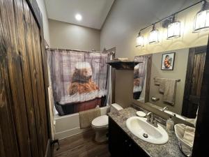 a bathroom with a dog shower curtain and a sink at Whispering Pines Cabin in Valemount +14 photos
