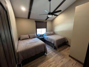 a bedroom with two beds and a ceiling fan at Whispering Pines Cabin in Valemount