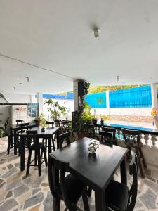 a restaurant with tables and chairs and a pool at Hotel Avenida 15 in Melgar