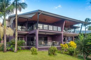 a purple house with palm trees in front of it at Anchorage Apartments on Hamilton Island by HIHA in Hamilton Island