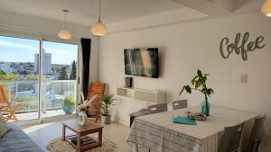 a living room with a table and a large window at Apart Alameda in Paraná