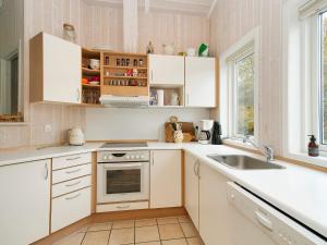 a kitchen with white cabinets and a sink at 8 person holiday home in Gilleleje in Udsholt Sand