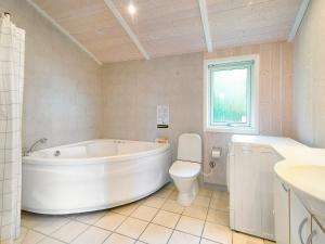 a bathroom with a tub and a toilet and a sink at 8 person holiday home in Gilleleje in Udsholt Sand