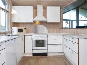 a kitchen with white cabinets and a stove top oven at 6 person holiday home in Harboøre-By Traum in Harboør