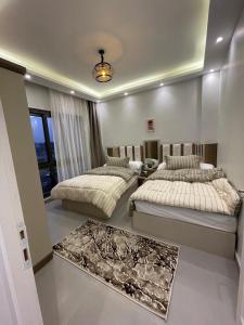 Madinatyにある2 bedrooms luxury hotel apartment in Madinatyのベッド2台とテーブルのある寝室
