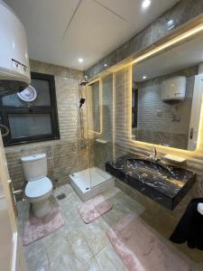Madinatyにある2 bedrooms luxury hotel apartment in Madinatyのトイレ、洗面台、浴槽を備えたバスルーム