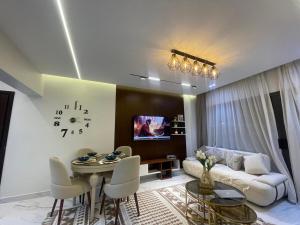 Madinatyにある2 bedrooms luxury hotel apartment in Madinatyのソファと壁掛け時計のあるリビングルーム