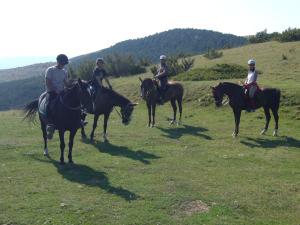 a group of people riding horses in a field at Casa Masover in Buira