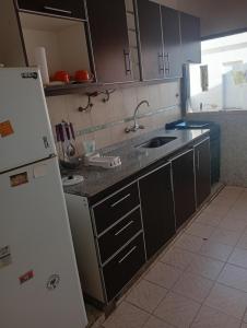a kitchen with a white refrigerator and a sink at Alojamiento Valle del Sol in San Fernando del Valle de Catamarca