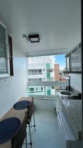 a kitchen with a table and chairs and a window at Studio Luxuoso in Cabo Frio