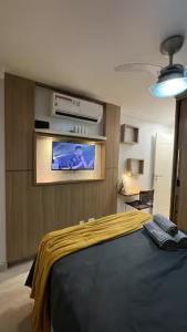 a bedroom with a bed and a tv on the wall at Studio Luxuoso in Cabo Frio +31 photos