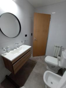 ein Badezimmer mit Waschbecken, Toilette und Spiegel in der Unterkunft DeptoBorgesJunin in Junín + 11 Fotos