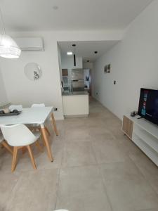 eine Küche und ein Wohnzimmer mit Tisch und Stühlen in der Unterkunft DeptoBorgesJunin in Junín