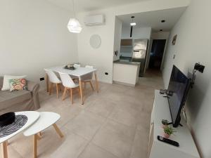 ein Wohnzimmer und eine Küche mit Tisch und Stühlen in der Unterkunft DeptoBorgesJunin in Junín
