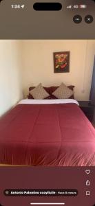 a bedroom with a bed with a red comforter at Pachamama house in Cusco +2 photos