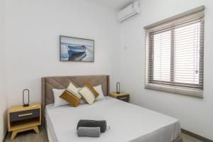 a white bedroom with a large bed and a window at Rocky 35 in Grand-Baie +9 photos