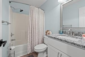 a bathroom with a toilet and a sink and a mirror at Charming upgraded 2-bed condo in amazing Pawleys Island True Blue Golf Course in Pawleys Island +22 photos