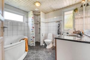 a bathroom with a tub and a toilet and a sink at C11324-Tarm-Blabaervej-6 in Tarm +37 photos