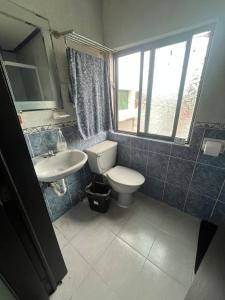 a bathroom with a toilet and a sink and a window at Acogedor Departamento en SLP in San Luis Potosí +35 photos